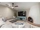 Cozy living room featuring a sectional sofa, brick fireplace, ceiling fan and a television at 7731 E Rose Ln, Scottsdale, AZ 85250