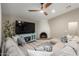 Cozy living room featuring a sectional sofa, brick fireplace, ceiling fan and a television at 7731 E Rose Ln, Scottsdale, AZ 85250