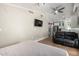 Living room with a ceiling fan, TV, leather sofa, and view into the kitchenette at 7731 E Rose Ln, Scottsdale, AZ 85250
