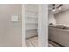 Walk-in pantry with built-in shelves, next to a living room with a sofa and ceiling fan at 7731 E Rose Ln, Scottsdale, AZ 85250