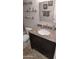 Granite-topped vanity with undermount sink, dark wood cabinets, and open shelving at 7910 E Camelback Rd # 302, Scottsdale, AZ 85251