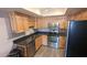 A kitchen featuring stainless steel appliances, wood cabinets, granite countertops, and light hardwood flooring at 7910 E Camelback Rd # 302, Scottsdale, AZ 85251