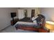 A main bedroom featuring a black colored bed, small bedside tables, a television stand and a view into the bathroom at 7910 E Camelback Rd # 302, Scottsdale, AZ 85251