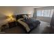 A main bedroom with bedside tables, a black colored bed, light gray walls, carpet and white blinds at 7910 E Camelback Rd # 302, Scottsdale, AZ 85251