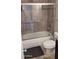 Bathroom featuring a shower-over-tub combination with tile surround and glass doors at 7910 E Camelback Rd # 302, Scottsdale, AZ 85251