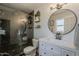 Modern bathroom featuring sleek vanity, stylish round mirror, and glass-enclosed shower with contemporary tile work at 8137 E Indian School Rd, Scottsdale, AZ 85251
