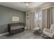 Cozy Bedroom with modern crib, natural light, and a comfortable rocking chair at 8137 E Indian School Rd, Scottsdale, AZ 85251