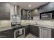 Well-equipped kitchen with stainless steel appliances, modern cabinets, and textured backsplash tiles at 8137 E Indian School Rd, Scottsdale, AZ 85251