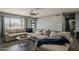 Comfortable living room with a large sectional sofa, modern ceiling fan, and a view to the front yard at 8137 E Indian School Rd, Scottsdale, AZ 85251