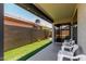 Covered patio area with seating, a view of the artificial turf lawn, and a block wall at 8720 W Willowbrook Dr, Peoria, AZ 85382