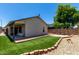 Landscaped backyard with artificial turf, brick edging, and a covered patio area perfect for relaxation at 8720 W Willowbrook Dr, Peoria, AZ 85382