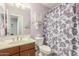 Well-lit bathroom with floral shower curtain, decorative butterfly art, and coordinated towels at 905 S Osborn Ln, Gilbert, AZ 85296