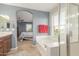 Bright bathroom featuring a soaking tub, glass shower, and a doorway to the main bedroom at 905 S Osborn Ln, Gilbert, AZ 85296