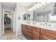 Bathroom with double vanity, wood cabinets, large mirror, and shower with glass door at 905 S Osborn Ln, Gilbert, AZ 85296