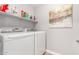 Well-organized laundry room with side-by-side washer and dryer and shelves for cleaning supplies at 905 S Osborn Ln, Gilbert, AZ 85296