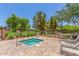 Community spa with brick trim surround, lush green grass and landscaping, and relaxing lounge chairs at 905 S Osborn Ln, Gilbert, AZ 85296