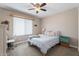 Comfortable bedroom with neutral tones, ceiling fan, and bright natural light from the window at 932 W Julie Dr, Tempe, AZ 85283
