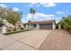 Charming single-story home with a well-maintained front yard, long driveway, and gray two car garage at 932 W Julie Dr, Tempe, AZ 85283