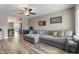 Bright living room featuring wood floors, neutral tones, a gray couch and a ceiling fan at 932 W Julie Dr, Tempe, AZ 85283