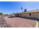 View of a lovely backyard, featuring desert landscaping, covered patio and bright blue skies at 10439 W Kingswood Cir, Sun City, AZ 85351