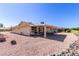Backyard with a covered patio, solar panels, and low-maintenance desert landscaping at 10439 W Kingswood Cir, Sun City, AZ 85351