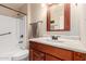 Classic bathroom with a wooden vanity, framed mirror, and a shower-tub combo at 10439 W Kingswood Cir, Sun City, AZ 85351