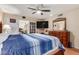 Cozy bedroom featuring a ceiling fan, TV, and French doors leading to another room at 10439 W Kingswood Cir, Sun City, AZ 85351