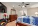 Comfortable bedroom featuring wood floors, ceiling fan, and a spacious closet at 10439 W Kingswood Cir, Sun City, AZ 85351