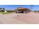 Wide view of the attached carport with desert landscaping and a well maintained driveway at 10439 W Kingswood Cir, Sun City, AZ 85351