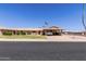 Charming single-story home featuring a covered parking, manicured lawn, and desert landscaping under a clear blue sky at 10439 W Kingswood Cir, Sun City, AZ 85351