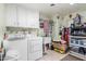 Functional laundry room with washer, dryer, sink, and storage shelves for organization at 10439 W Kingswood Cir, Sun City, AZ 85351