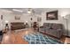Inviting living room with wood floors, skylight, traditional furniture and a view to the dining room at 10439 W Kingswood Cir, Sun City, AZ 85351