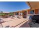 Cozy outdoor patio with tile flooring, brick accents, and outdoor furniture, perfect for relaxing and grilling at 10439 W Kingswood Cir, Sun City, AZ 85351