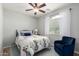 Bedroom with a cozy blue chair, decorative white curtains, and a ceiling fan for added comfort at 1229 W Sycamore Rd, Queen Creek, AZ 85140