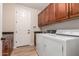 Functional laundry room featuring ample cabinet space, modern machines, and convenient sink area at 1229 W Sycamore Rd, Queen Creek, AZ 85140