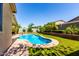 Sparkling kidney-shaped pool with lush landscaping and surrounding brick pavers provide a relaxing backyard oasis at 1229 W Sycamore Rd, Queen Creek, AZ 85140