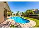 Beautiful kidney-shaped pool surrounded by lush landscaping, brick pavers, and a covered patio perfect for entertaining at 1229 W Sycamore Rd, Queen Creek, AZ 85140