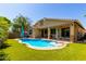 Beautiful backyard pool with an umbrella, surrounded by artificial grass and easy access to the home at 1229 W Sycamore Rd, Queen Creek, AZ 85140