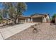 A long driveway leads to a 3 car garage on this single story home with desert landscaping at 12360 W Eagle Ridge Ln, Peoria, AZ 85383