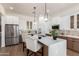 Modern kitchen boasts stainless steel appliances, quartz countertops, and an island with seating at 12360 W Eagle Ridge Ln, Peoria, AZ 85383