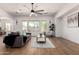 Bright living room features wood floors, modern ceiling fan, and natural light from large windows at 12360 W Eagle Ridge Ln, Peoria, AZ 85383