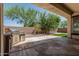 Covered patio featuring a built-in grill, landscaped yard, and brick wall at 12360 W Eagle Ridge Ln, Peoria, AZ 85383