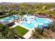 Aerial view of a community pool complex, complete with multiple pools, a slide, sunshades, and lounge chairs at 12360 W Eagle Ridge Ln, Peoria, AZ 85383