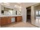 Luxurious primary bath with dual sinks, large mirror, soaking tub, walk-in closet, and tile flooring at 13657 W Holly St, Goodyear, AZ 85395