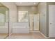 Bright bathroom featuring tile flooring, a garden tub, and a separate glass shower with modern fixtures at 13657 W Holly St, Goodyear, AZ 85395