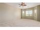 Inviting bedroom with plush carpet, multiple windows offering natural light, and a modern ceiling fan at 13657 W Holly St, Goodyear, AZ 85395