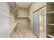 Carpeted walk-in closet with neutral walls, wooden shelving, and a view into the bathroom at 13657 W Holly St, Goodyear, AZ 85395