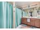 Clean bathroom featuring a double sink vanity, shower with a blue curtain, and ample lighting at 14575 W Mountain View Blvd # 12309, Surprise, AZ 85374