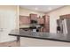 Well-equipped kitchen with stainless steel appliances, plenty of cabinets, and black countertop at 14575 W Mountain View Blvd # 12309, Surprise, AZ 85374