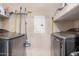 Functional laundry area with modern washer and dryer units, shelving, and practical cleaning supplies at 14575 W Mountain View Blvd # 12309, Surprise, AZ 85374